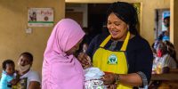 Rotarian and Lagos State immunization officer Bola Orefejo (right) vaccinates a child against polio at Ikosi Health Center in Lagos, Nigeria. 28 July 2020. Find the story in "Rotary" magazine, October 2020.